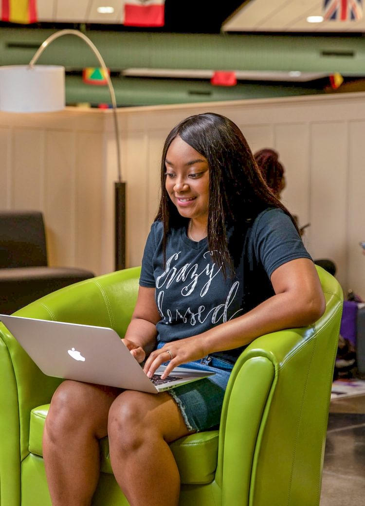 a student uses her computer in a common area on campus