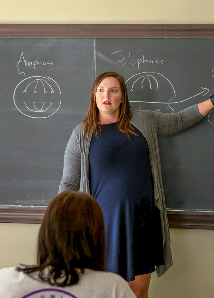 a professor smiles during a lecture
