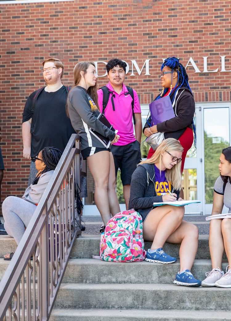 students gather on steps outside of class