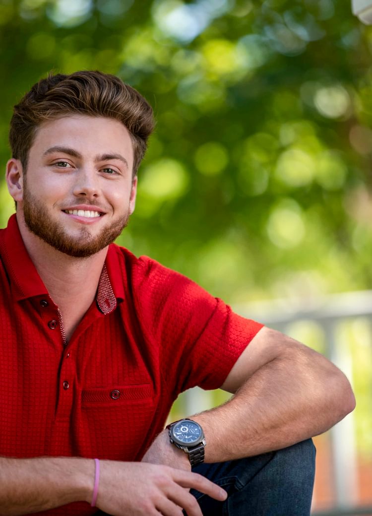 student sits out under gazebo on campus