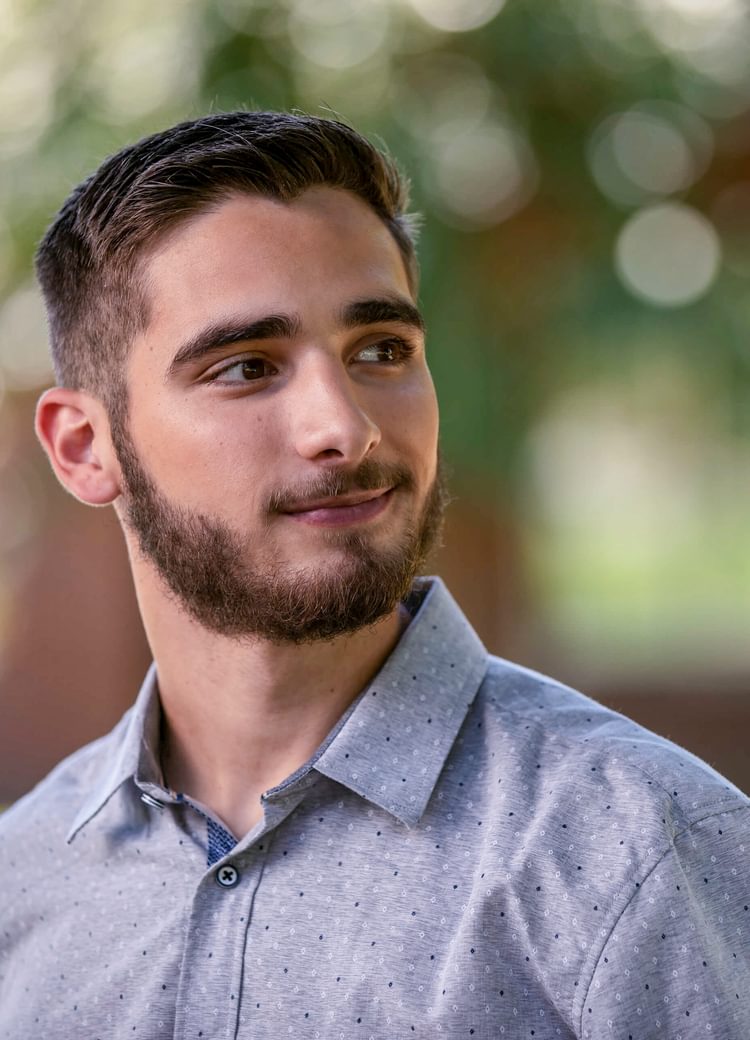 a male student looks of camera during an outdoor portrait