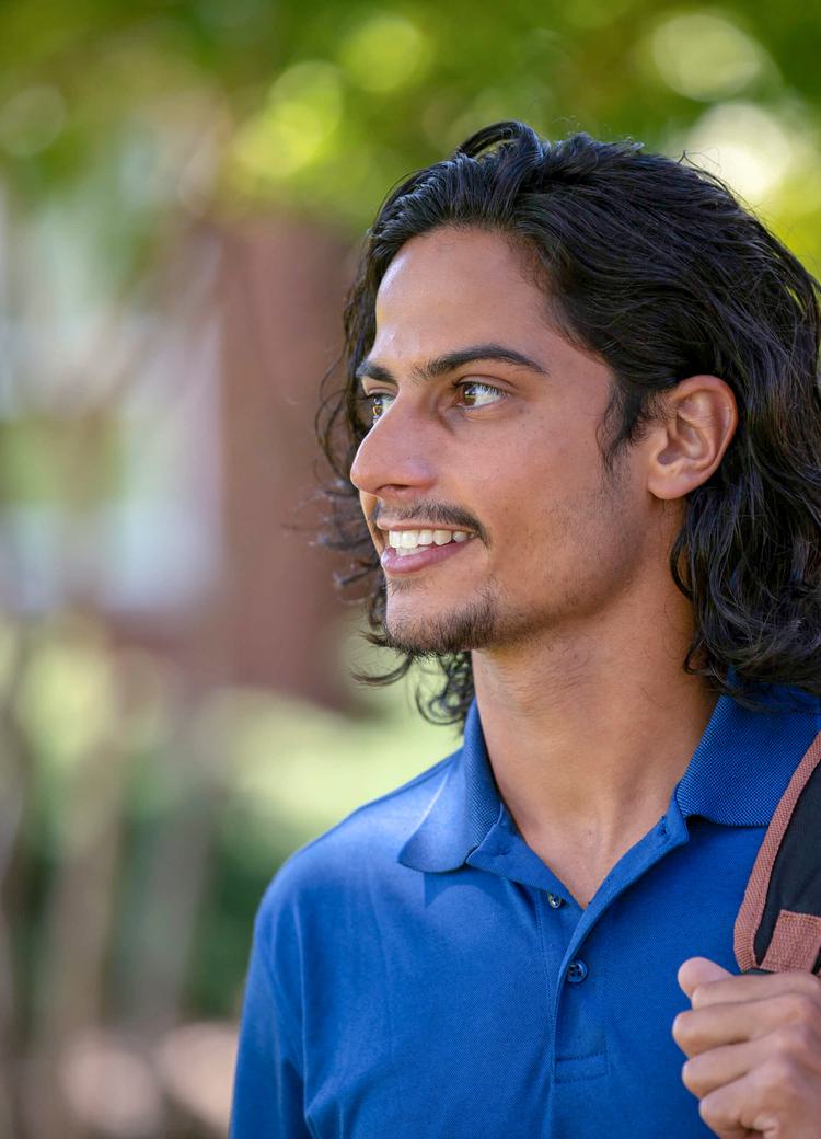 a student with a backpack looks off camera