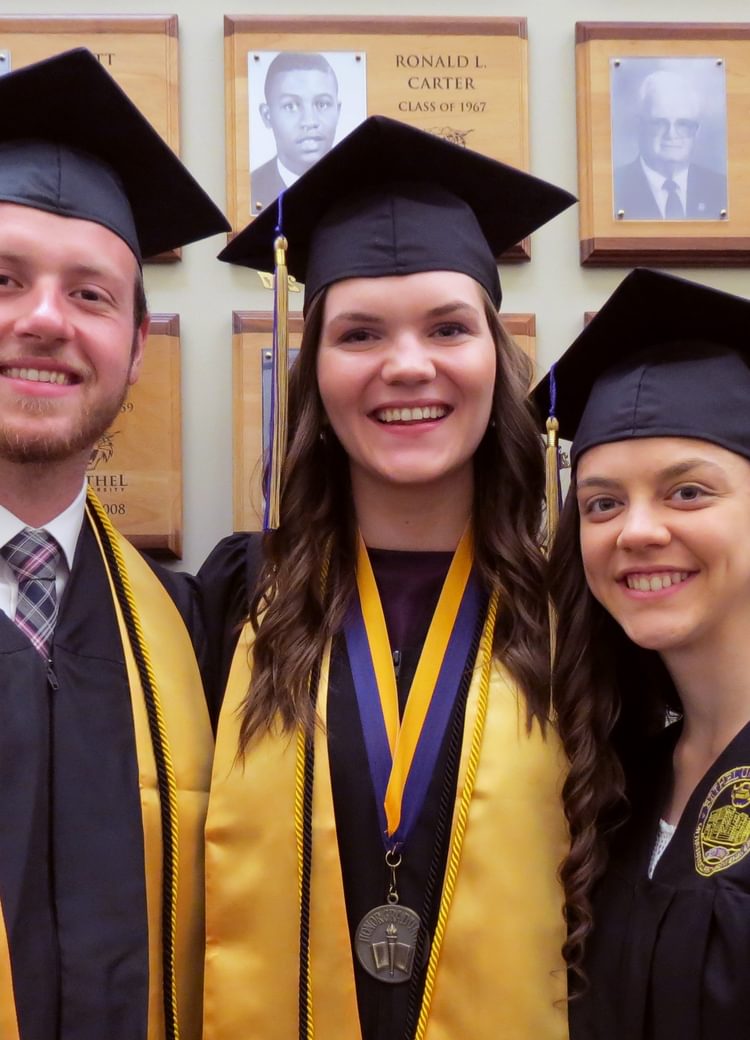 several recent grads smile for a picture