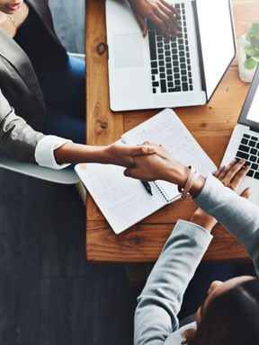 a pair of business partners celebrate a deal with a handshake