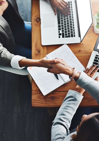 a pair of business partners celebrate a deal with a handshake