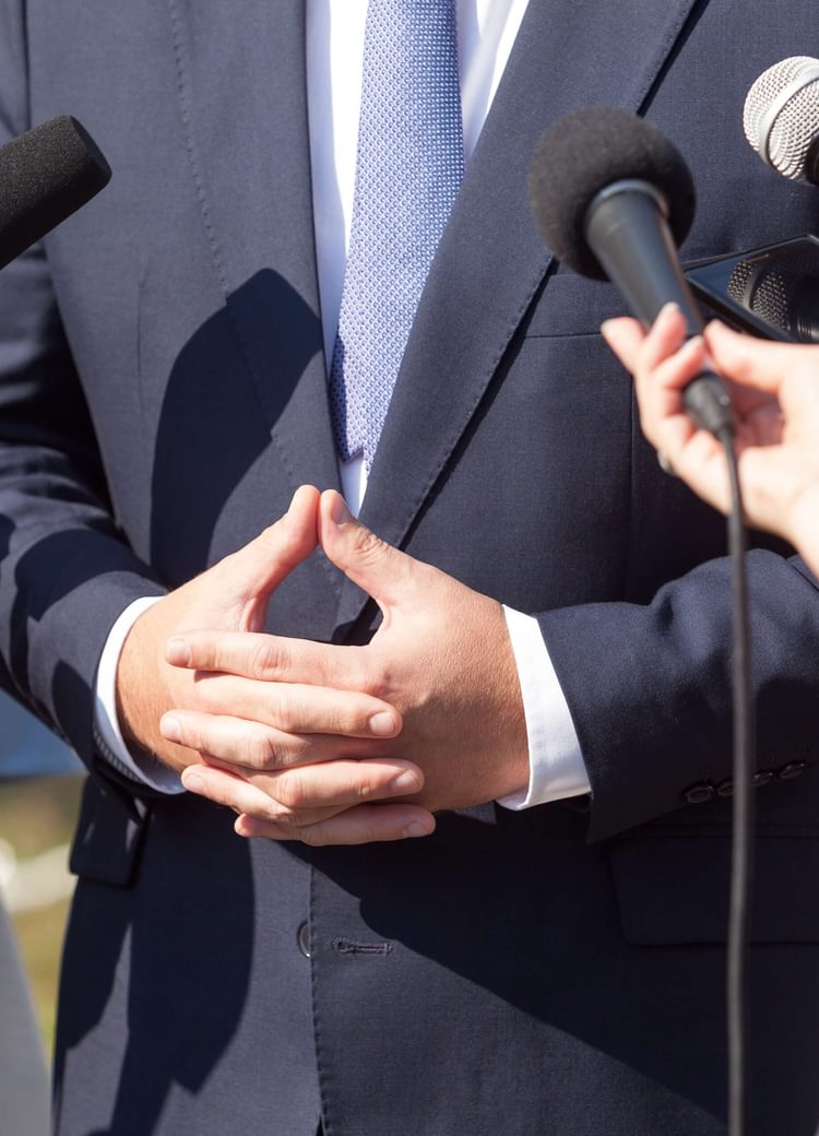 an emergency management professional gathers in front of microphones