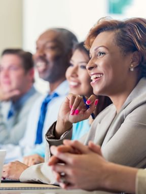 a group of business people listen to a presentation