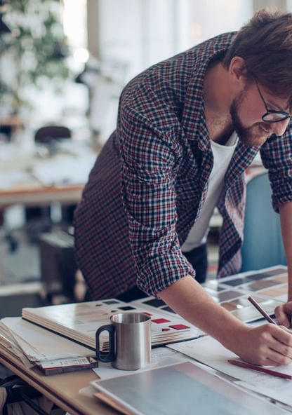 a student takes notes on some work at his desk