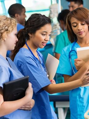 a nursing student speaks with her professor during an anatomy lab
