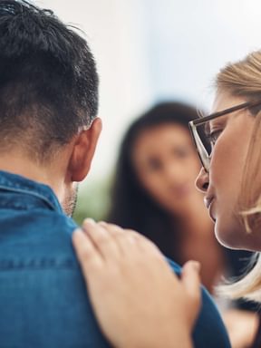 a psychologist consoles a patient with a pat on the back