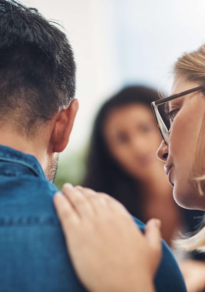 a psychologist consoles a patient with a pat on the back