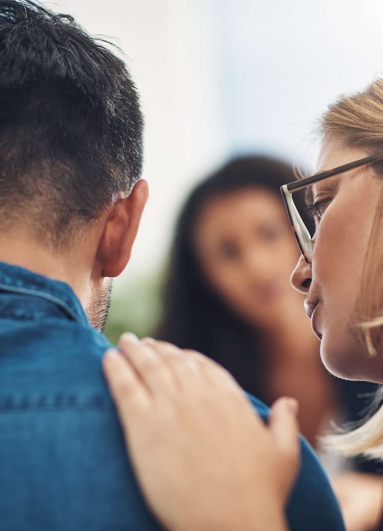 a psychologist consoles a patient with a pat on the back