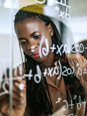 a student uses a glass wall to solve a mathematical equation