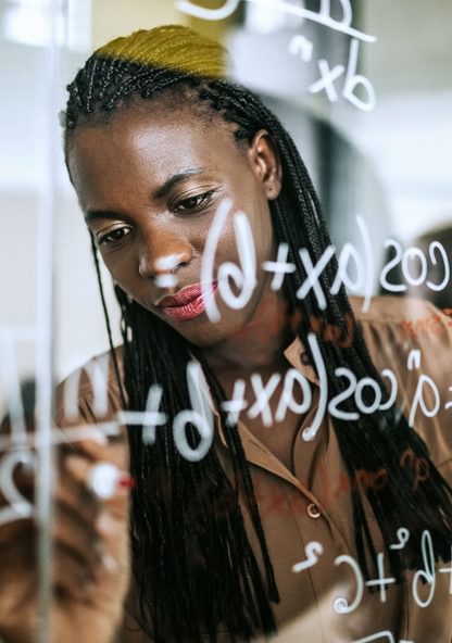 a student uses a glass wall to solve a mathematical equation