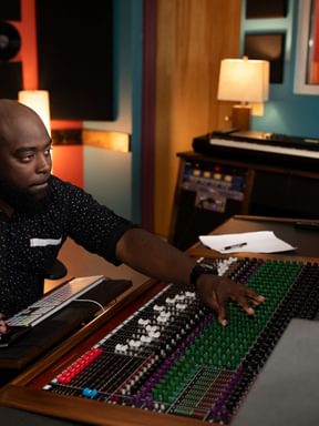 A sound engineer using the mixer in a recording studio