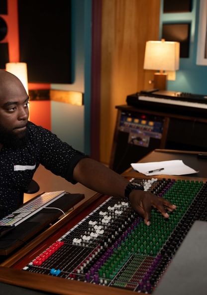 A sound engineer using the mixer in a recording studio