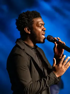 Student vocalist singing during a live performance.