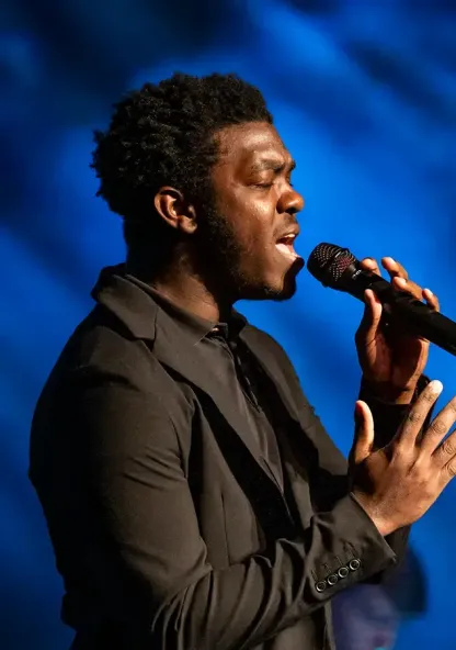 Student vocalist singing during a live performance.