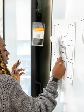 Student writing on a whiteboard during a classroom activity