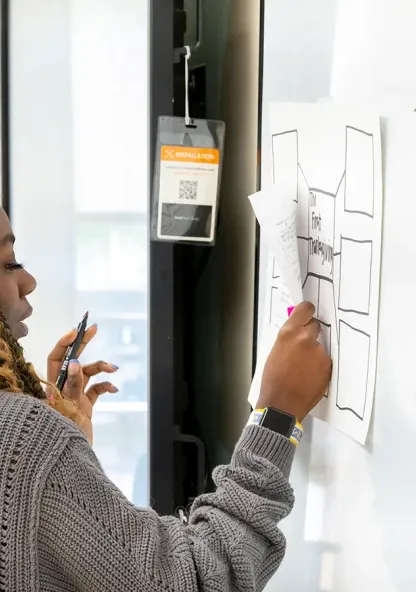 Student writing on a whiteboard during a classroom activity