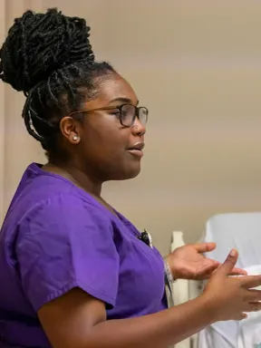 Nursing student demonstrates patient care skills in a simulation lab.