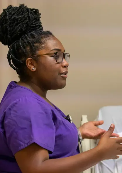 Nursing student demonstrates patient care skills in a simulation lab.