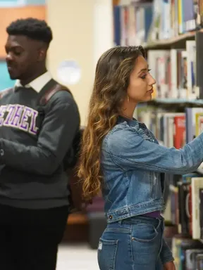 College students studying and browsing books in the library