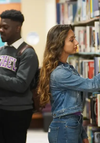 College students studying and browsing books in the library