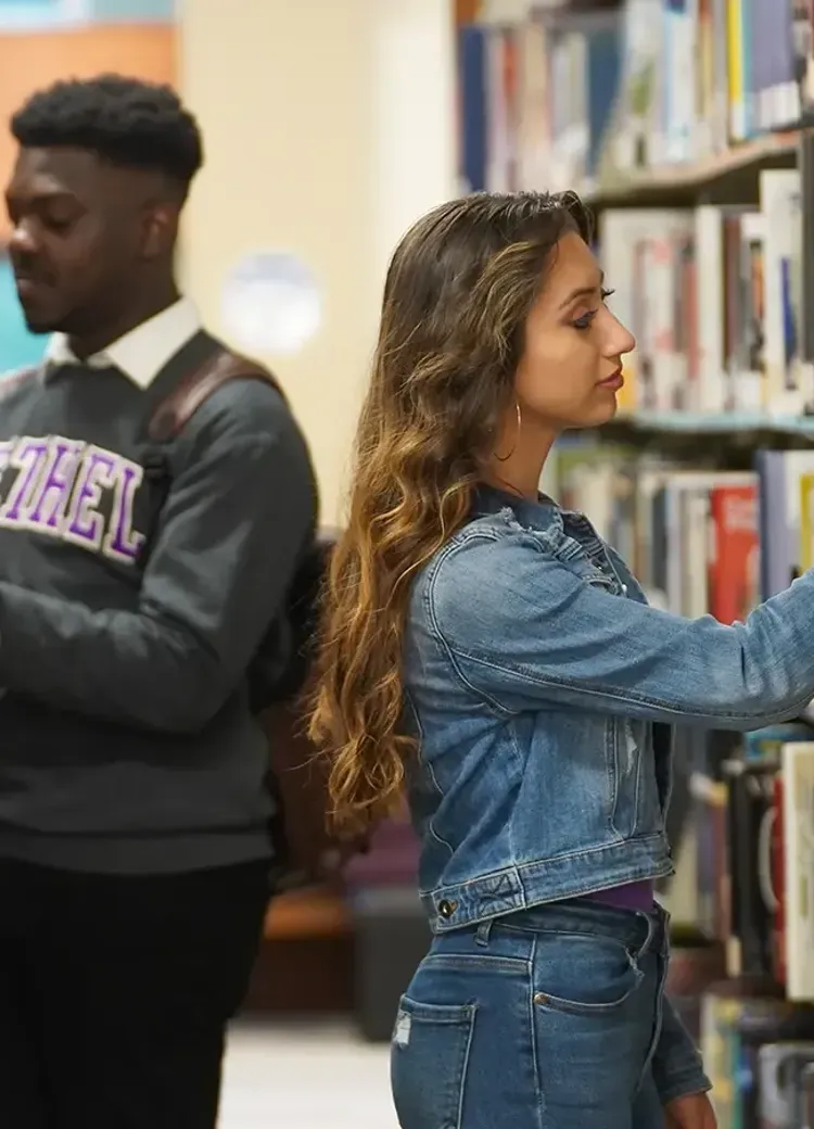 College students studying and browsing books in the library