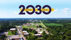 Aerial shot of Bethel University's campus beneath the gold-and-purple Bethel Vision 2030 logo.