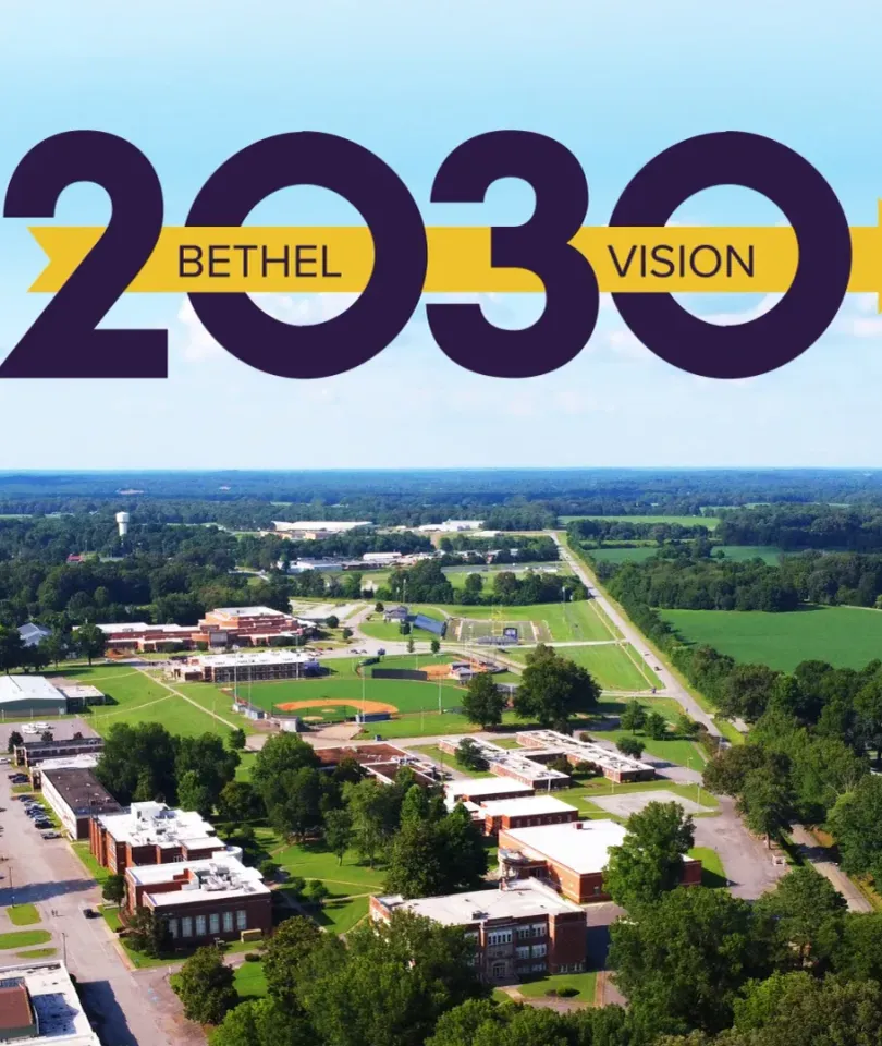 Aerial shot of Bethel University's campus beneath the gold-and-purple Bethel Vision 2030 logo.